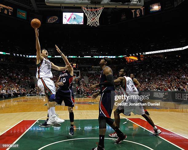 Carlos Delfino of the Milwaukee Bucks puts up a shot over Mike Bibby of the Atlanta Hawks in Game Six of the Eastern Conference Quarterfinals during...