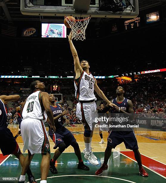 Carlos Delfino of the Milwaukee Bucks puts up a shot over teammate Kurt Thomas and Joe Johnson and Marvin Williams of the Atlanta Hawks in Game Six...