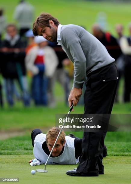 Robert Rock of England and caddie line up his putt on the 15th hole during the second round of the BMW Italian Open at Royal Park I Roveri on May 7,...