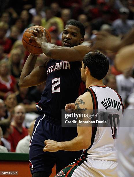 Joe Johnson of the Atlanta Hawks tries to pass over Carlos Delfino of the Milwaukee Bucks in Game Six of the Eastern Conference Quarterfinals during...