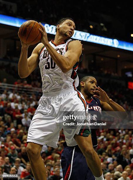 Dan Gadzuric of the Milwaukee Bucks grab a rebound over Al Horford of the Atlanta Hawks in Game Six of the Eastern Conference Quarterfinals during...