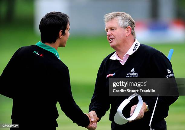 Matteo Manassero of Italy shakes hands with Ryder Cup captain Colin Montgomerie of Scotland on the 18th hole during the second round of the BMW...