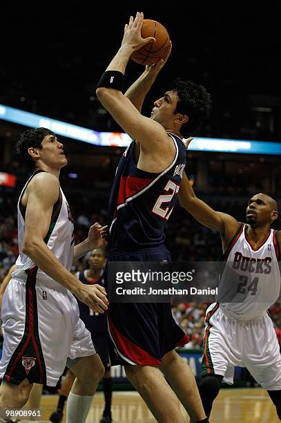 Zaza Pachulia of the Atlanta Hawks shoots the ball over Ersan Ilyasova and Jerry Stackhouse of the Milwaukee Bucks in Game Six of the Eastern...