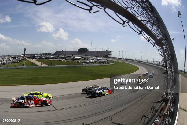 Kyle Busch, driver of the Skittles Red White & Blue Toyota, races Paul Menard, driver of the Menards/Sylvania Ford, during the Monster Energy NASCAR...
