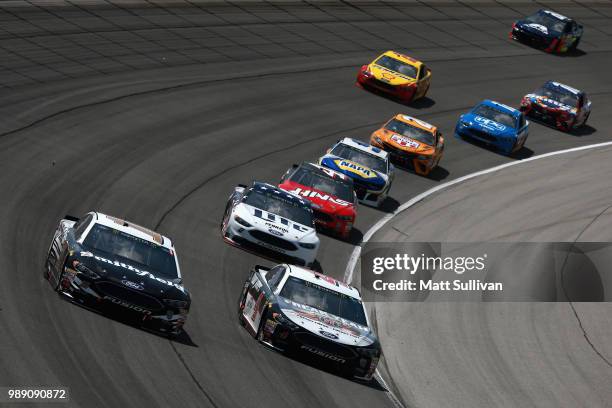 Aric Almirola, driver of the Smithfield Ford, and Kevin Harvick, driver of the Jimmy John's Kickin' Ranch Ford, lead a pack of cars during the...