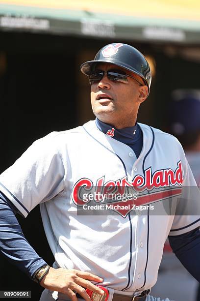 First Base Coach Sandy Alomar, Jr. #15 of the Cleveland Indians standing in the dugout during the game against the Oakland Athletics at the Oakland...