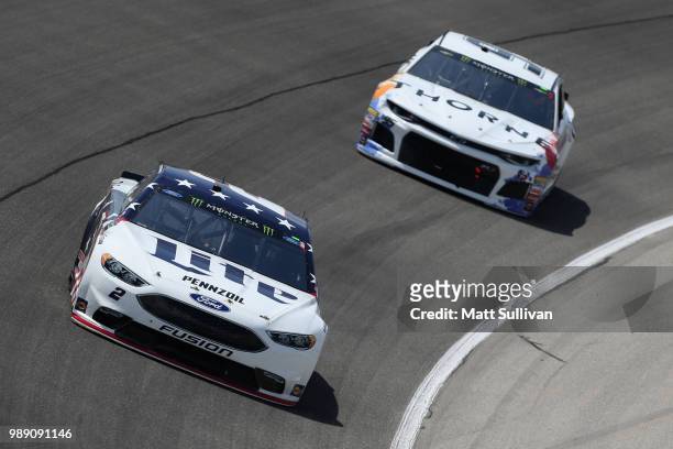 Brad Keselowski, driver of the Stars Stripes and Lites Ford, leads Kasey Kahne, driver of the Thorne Wellness Toyota, during the Monster Energy...