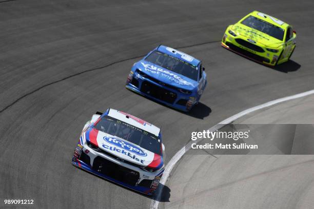 Allmendinger, driver of the Kroger ClickList Chevrolet, leads Chris Buescher, driver of the Kleenex Wet Wipes Chevrolet, and Paul Menard, driver of...