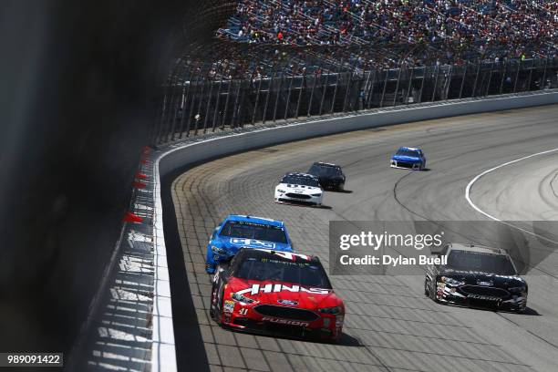 Kurt Busch, driver of the Haas Automation Ford, and Aric Almirola, driver of the Smithfield Ford, lead a pack of cars during the Monster Energy...