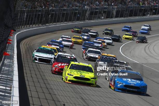 Ryan Blaney, driver of the PPG Ford, and Paul Menard, driver of the Menards/Sylvania Ford, lead the field into turn one following the start of the...