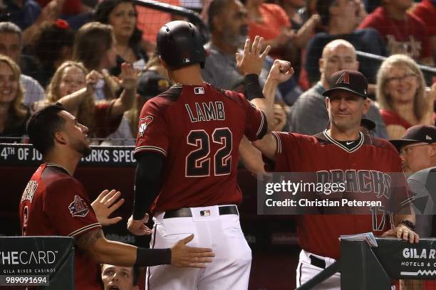 Manager Torey Lovullo of the Arizona Diamondbacks high fives Jake Lamb after scoring against the San Francisco Giants during the second inning of the...