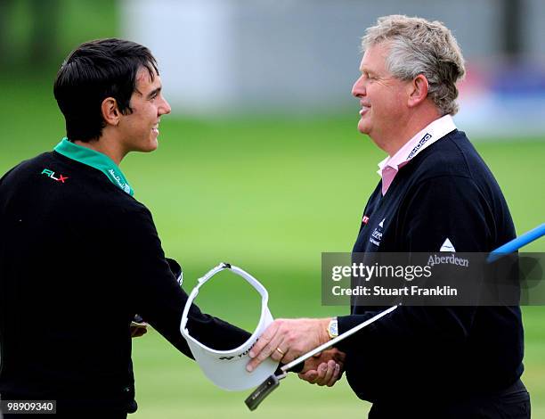 Matteo Manassero of Italy shakes hands with Ryder Cup captain Colin Montgomerie of Scotland on the 18th hole during the second round of the BMW...