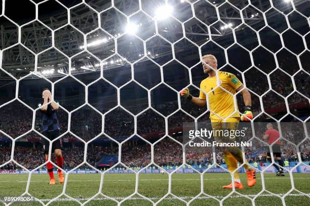 Milan Badelj of Croatia reacts after missing his team's first penalty in the penalty shoot out as Kasper Schmeichel of Denmark celebrates during the...