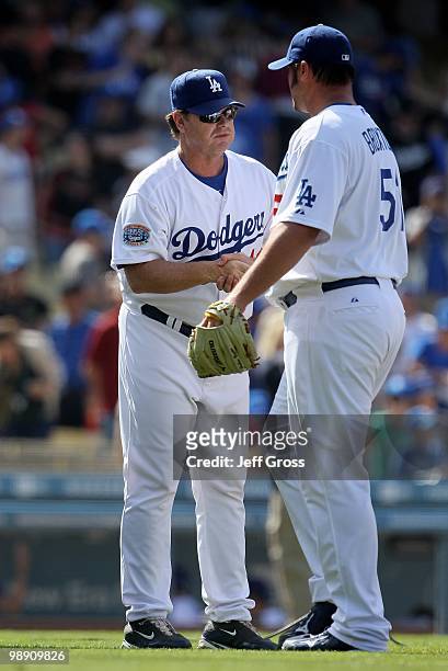 Pitching coach Rick Honeycutt of the Los Angeles Dodgers congratulates Jonathan Broxton against the San Francisco Giants at Dodger Stadium on April...