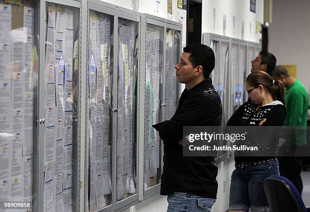 Job seekers look at job listings posted on bulletin boards at the Career Link Center One Stop job center May 7, 2010 in San Francisco, California. A...