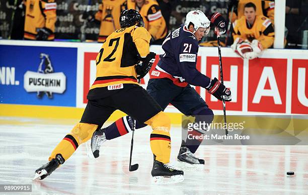 Alexander Sulzer of Germany and Kyle Okposo of USA compete for the puck during the IIHF World Championship group D match between USA and Germany at...
