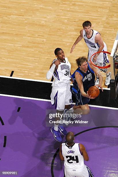 Dirk Nowitzki of the Dallas Mavericks goes up for a shot against Carl Landry and Jason Thompson of the Sacramento Kings during the game at Arco Arena...