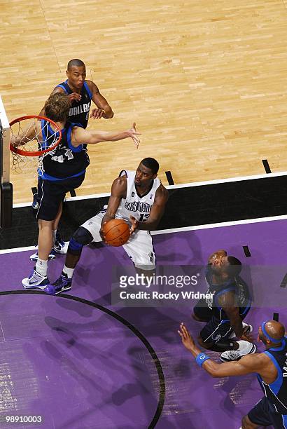 Tyreke Evans of the Sacramento Kings drives to the basket for a layup against Dirk Nowitzki and DeShawn Stevenson of the Dallas Mavericks during the...