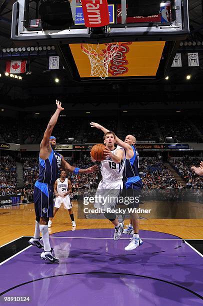 Beno Udrih of the Sacramento Kings drives to the basket for a layup between Erick Dampier and Jason Kidd of the Dallas Mavericks during the game at...