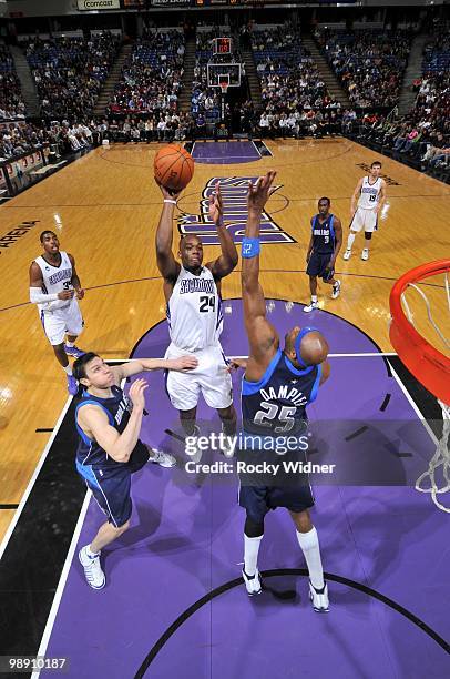 Carl Landry of the Sacramento Kings goes up for a shot against Eduardo Najera and Erick Dampier of the Dallas Mavericks during the game at Arco Arena...