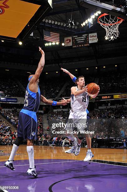 Beno Udrih of the Sacramento Kings drives to the basket for a layup between Erick Dampier and Jason Kidd of the Dallas Mavericks during the game at...