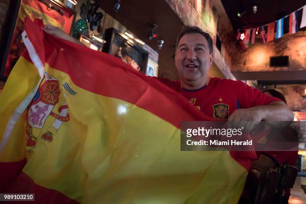 Soccer fan Juan Carlos Muniz waves his Spanish flag at Tapas and Tintos, a restaurant in Miami Beach, Fla. Where fans gathered to watch Spain take on...