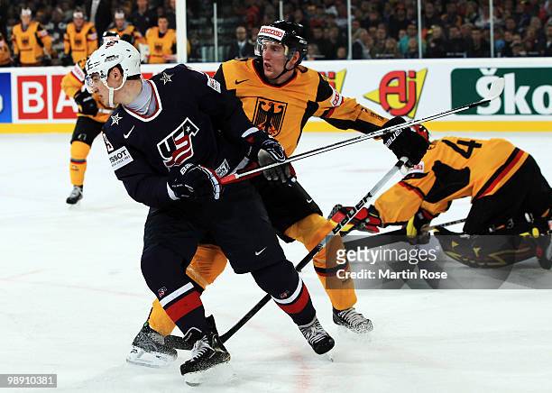 Justin Krueger of Germany tackles Chris Kreider of USA during the IIHF World Championship group D match between USA and Germany at Veltins Arena on...