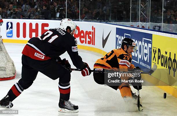 Alexander Barta of Germany and Kyle Okposo of USA compete for the puck during the IIHF World Championship group D match between USA and Germany at...