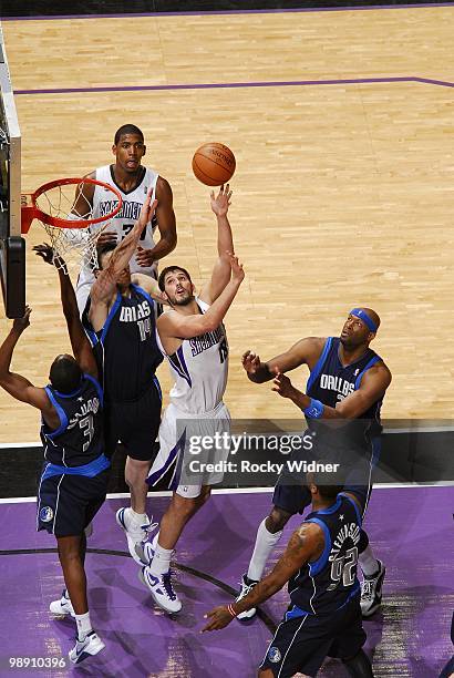 Omri Casspi of the Sacramento Kings shoots a layup against Eduardo Najera, Rodrigue Beaubois, Erick Dampier and DeShawn Stevenson of the Dallas...