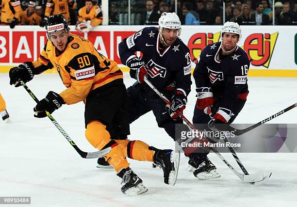 Constantin Braun of Germany, Eric Nystrom and Ryan Potulny of USA compete for the puck during the IIHF World Championship group D match between USA...