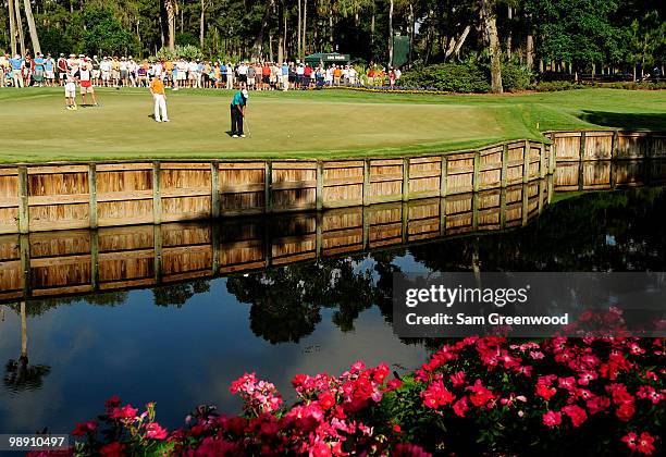 Tiger Woods putts on the 13th green as Hunter Mahan and Ian Poulter of England look on during the second round of THE PLAYERS Championship held at...