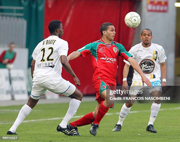 Sedan's forward Eyemen Henaini vies with Arles-Avignon's midfielder Ndiaye Ndiaye and defender Marvin Esor during the French L2 football match Sedan...