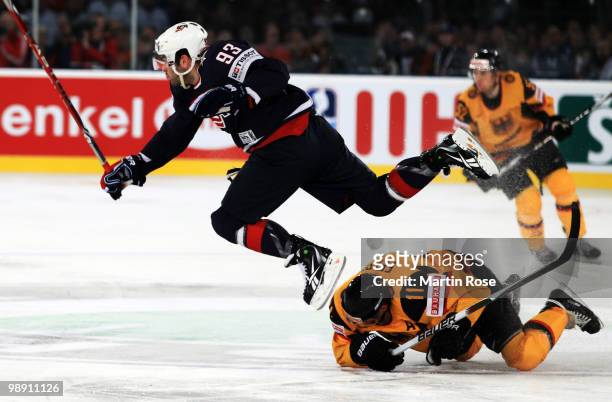 Keith Yandle of USA jumps over Sven Felski of Germany during the IIHF World Championship group D match between USA and Germany at Veltins Arena on...