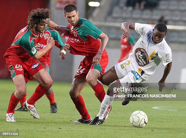 Sedan's defender Paul Baysse and midfielder's Pierrick Valdivia fight for the ball with Arles-Avignon's midfielder Ndiaye Deme Ndiaye during the...