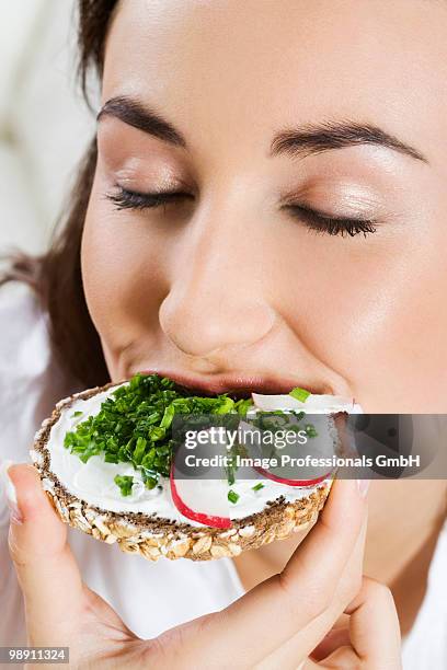 young woman eating sandwich with wholemeal bread. - vollkornbrot stock-fotos und bilder