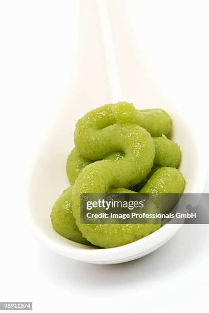 wasabi paste on spoon against white background. - wasabi paste stock pictures, royalty-free photos & images