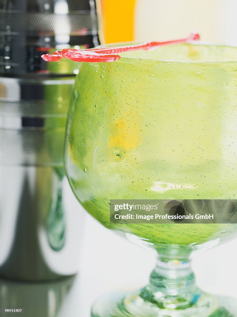 Green cocktail glass with cocktail shaker.