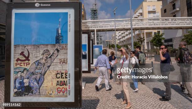 Visitors walk during a guided tour by pictures from the open air photo exhibition "Voce Nao Esta Aqui" by Portuguese photojournalist Bruno Portela,...