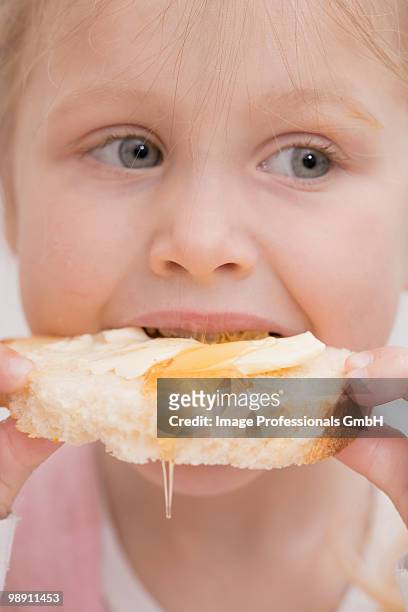baby girl (12-23 months) eating bread with honey, close-up - 12 23 months stock pictures, royalty-free photos & images