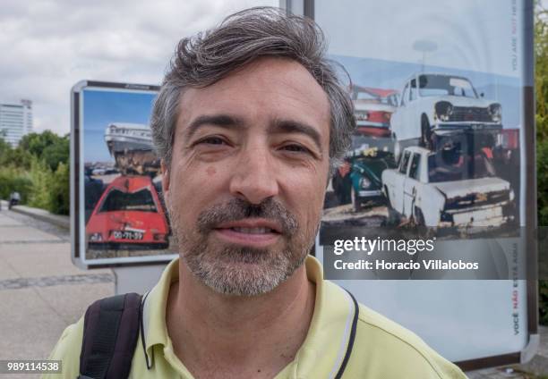 Portuguese photojournalist Bruno Portela stands before some of his photos during a guided tour of his open air photo exhibition "Voce Nao Esta Aqui"...