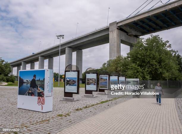 Woman walks by pictures from the open air photo exhibition "Voce Nao Esta Aqui" by Portuguese photojournalist Bruno Portela depicting the area as it...