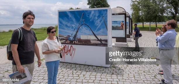 Visitors seen by pictures from the open air photo exhibition "Voce Nao Esta Aqui" by Portuguese photojournalist Bruno Portela, depicting the area as...