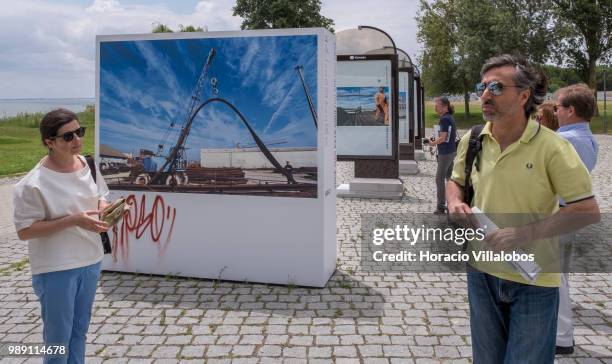 Portuguese photojournalist Bruno Portela briefs visitors on a guided tour of his open air photo exhibition "Voce Nao Esta Aqui" , depicting the area...