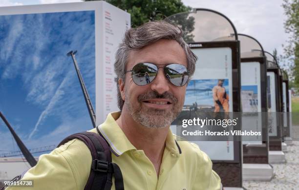 Portuguese photojournalist Bruno Portela smiles while briefing visitors on a guided tour of his open air photo exhibition "Voce Nao Esta Aqui" ,...