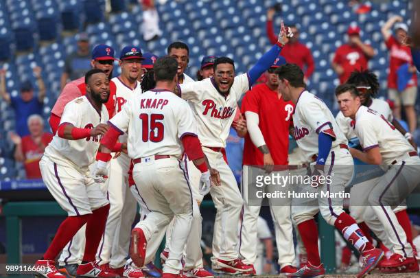 The Philadelphia Phillies surround home plate to celebrate with Andrew Knapp after he hit a game winning, walk off, solo home run in the 13th inning...