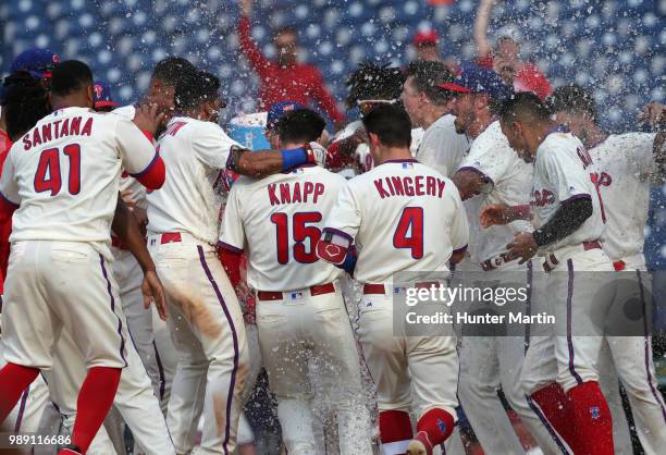 The Philadelphia Phillies surround home plate and celebrate with Andrew Knapp after he hit a game winning, walk off, solo home run in the 13th inning...