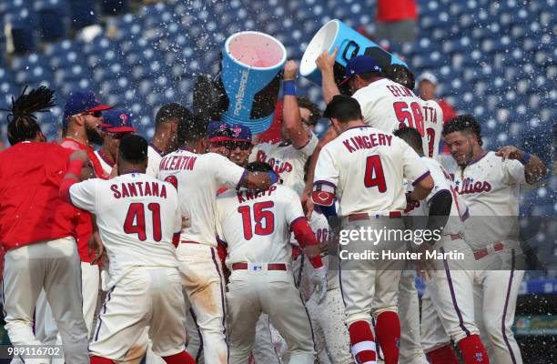 The Philadelphia Phillies surround home plate and celebrate with Andrew Knapp after he hit a game winning, walk off, solo home run in the 13th inning...