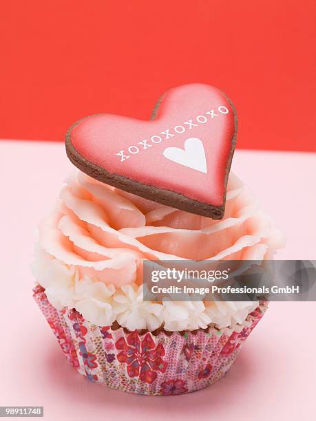 cupcake with marzipan rose and red heart shape pastry, close-up - forma de queque imagens e fotografias de stock