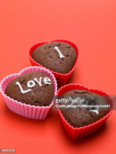 heart shaped chocolate muffins on red background, close-up - forma de queque imagens e fotografias de stock