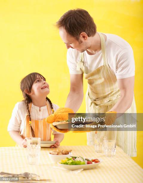 father and daughter (6-7) laying table - gant de cuisine photos et images de collection